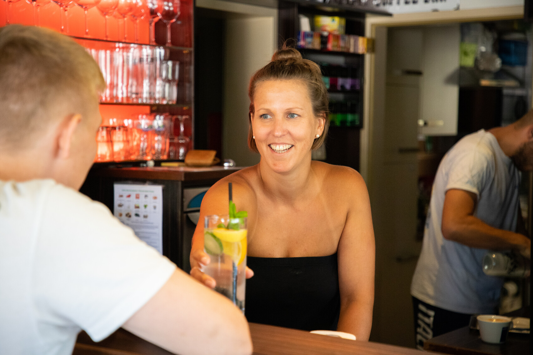 Bedienung an der Bar reicht ein erfrischendes Getränk