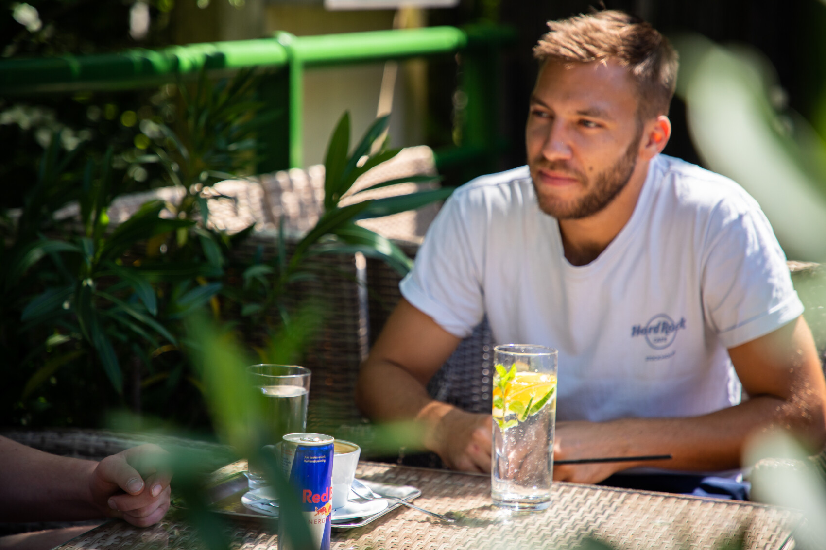 Gäste im schattigen Gastgarten mit Kaffee und Getränken